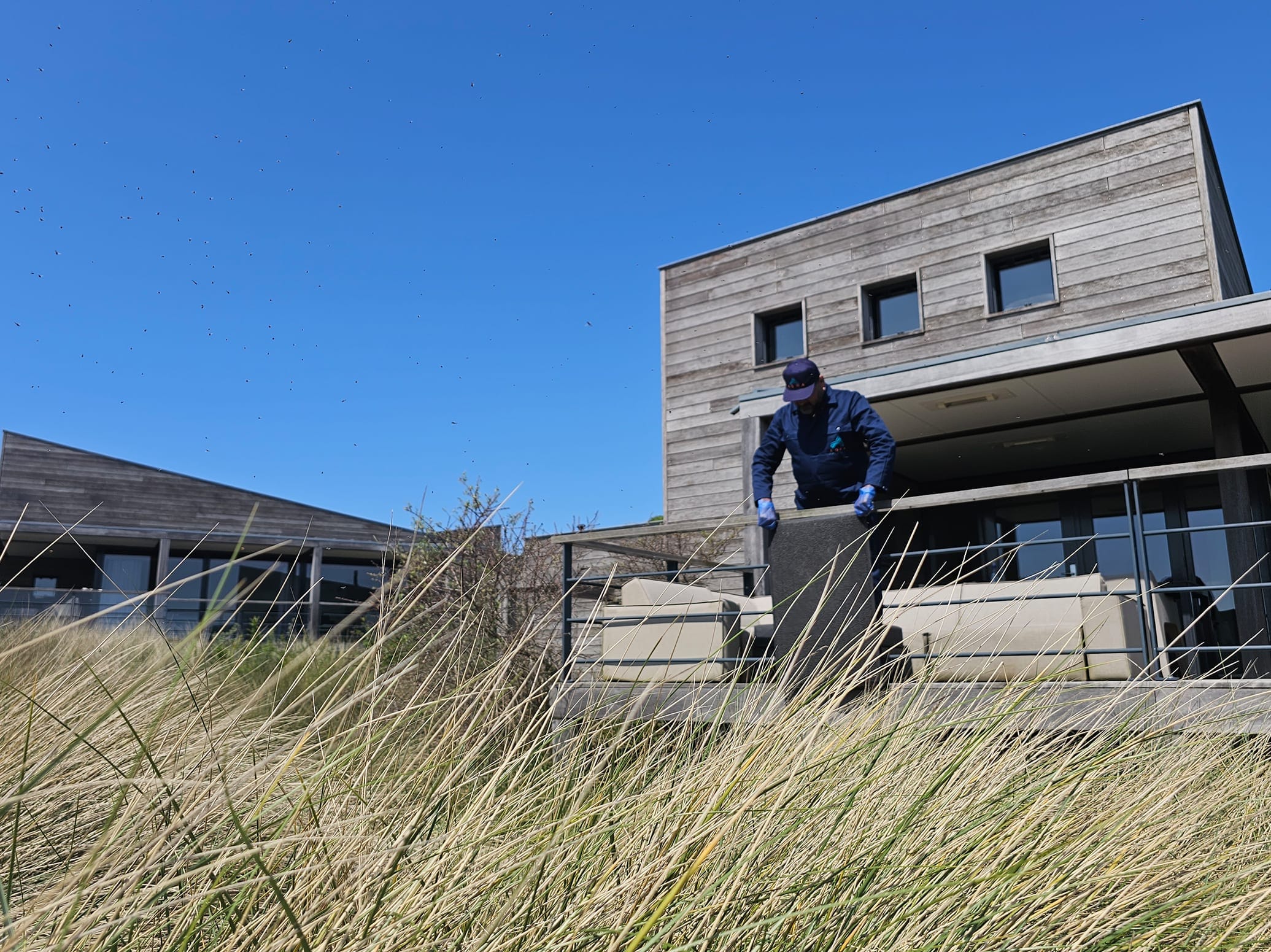 AQWA schoonmaakmedewerker in donkerblauw uniform aan het werk in een premium hospitality-ruimte